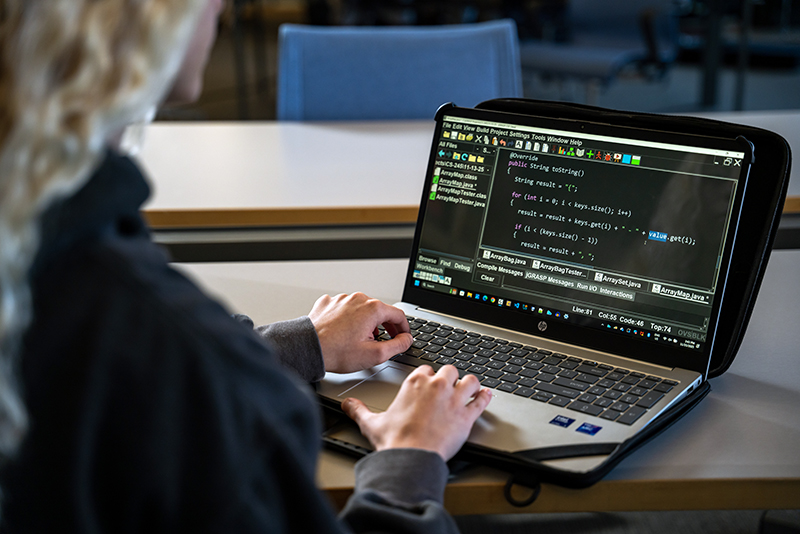 a student typing code on a computer